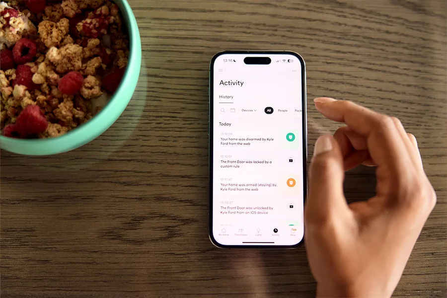 Person using the Vivint App on a breakfast table